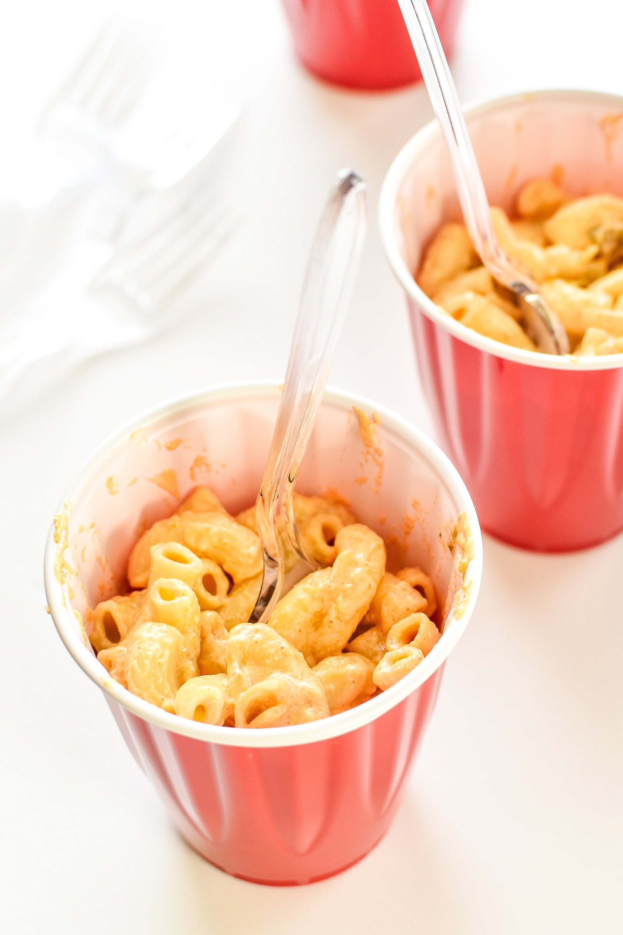 Two cupfuls of white cheddar camping mac and cheese with forks.