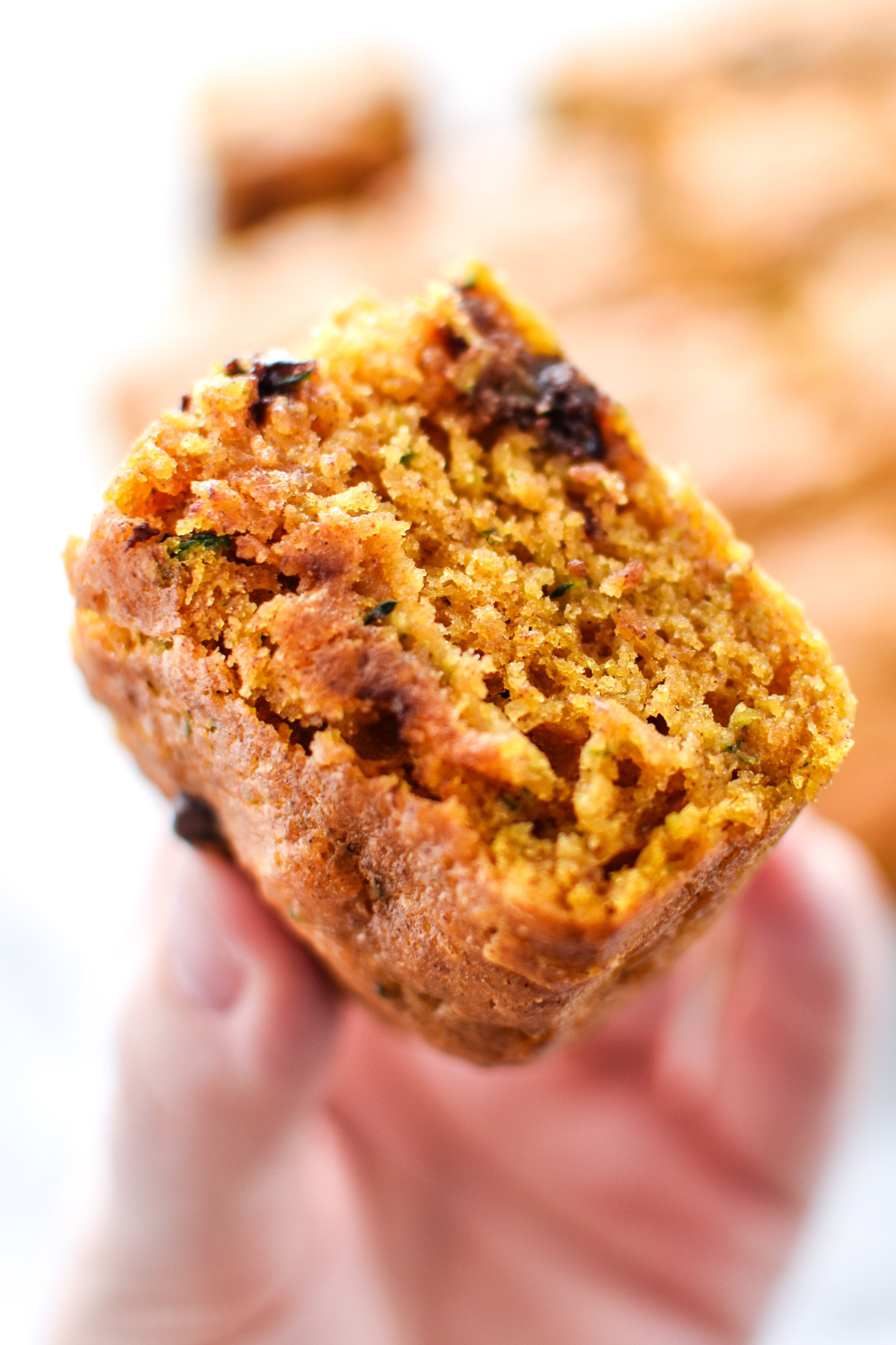 A hand holding a piece of zucchini bread square. 