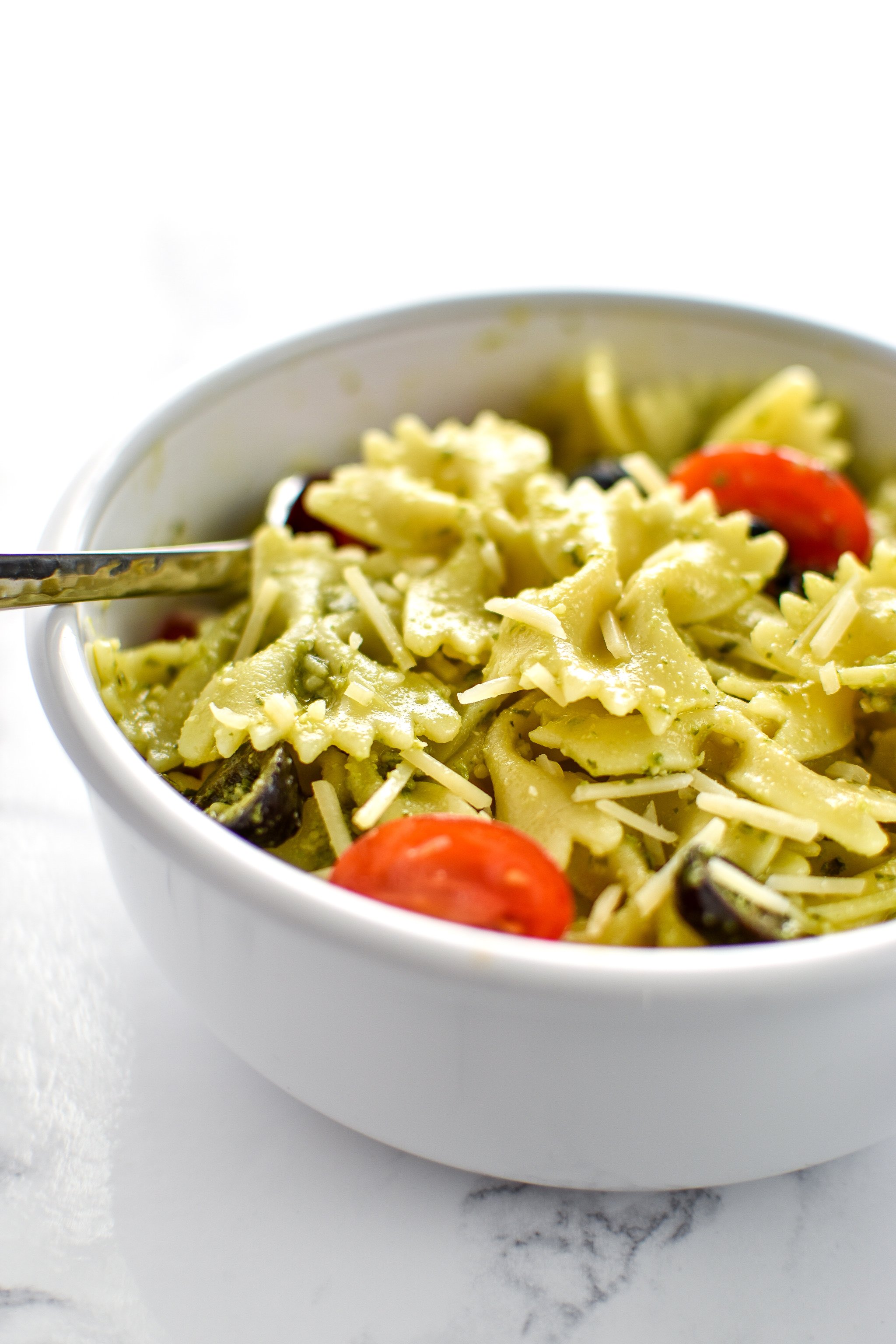 A delicious bowl of Incredibly Easy Pesto Pasta Salad - just 6 simple ingredients for the best make-ahead side dish! - ProjectMealPlan.com