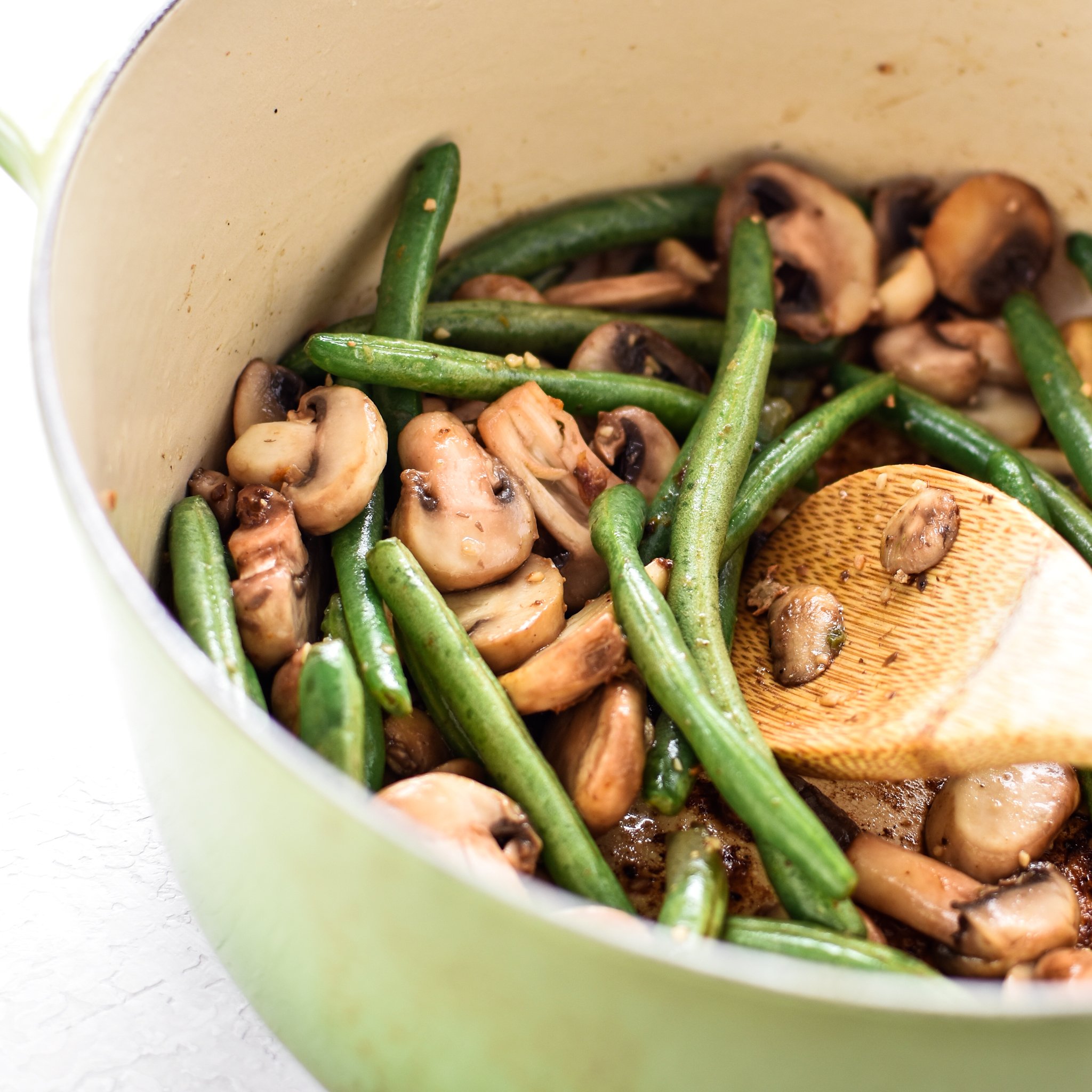 Mushrooms and green beans cooking the Dutch Oven. This One-Pot Pesto Chicken and Rice is the perfect idea if you're short on dinner prep time. - ProjectMealPlan.com