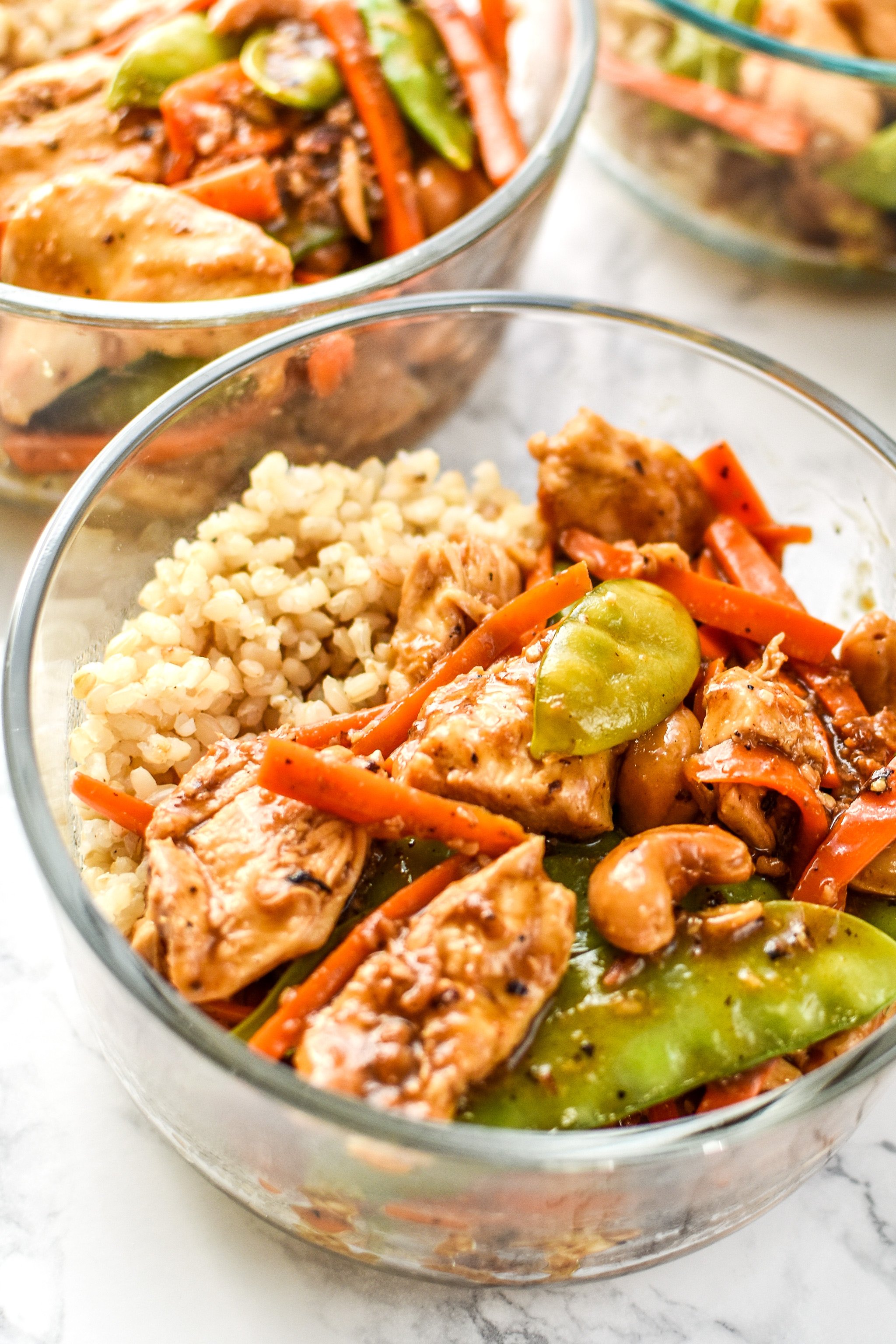 Cashew Chicken meal prep with rice in glass Pyrex bowls.