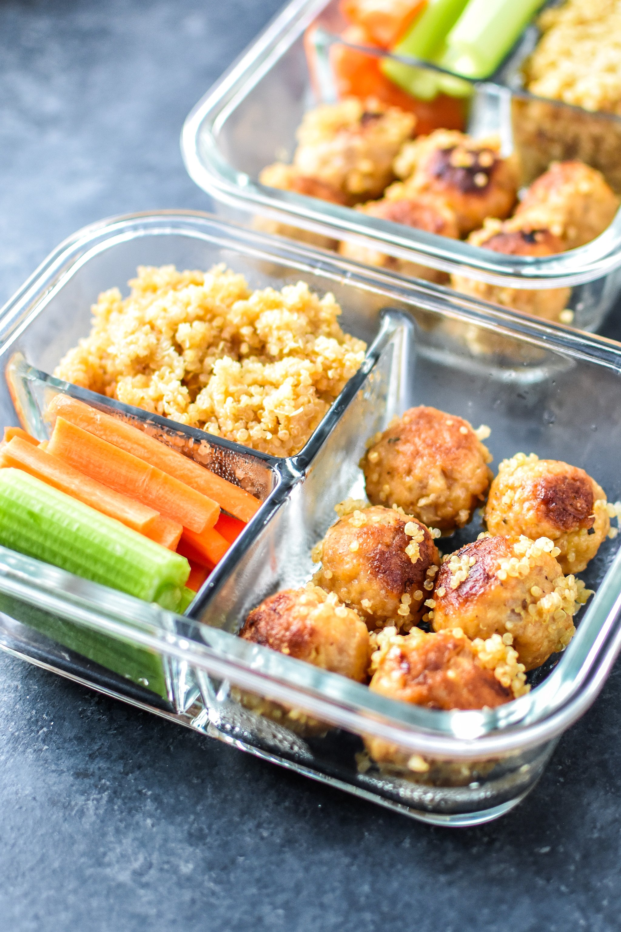 Buffalo chicken meatballs with quinoa and raw veggies in glass meal prep containers.