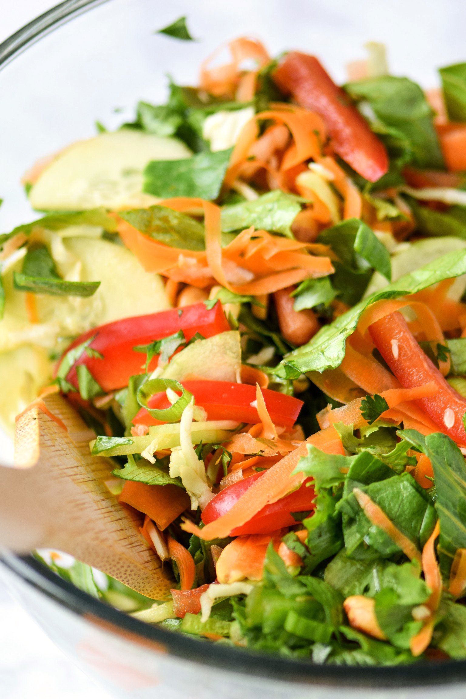 Colorful thai inspired salad with romaine, cilantro, bell peppers, carrots and cucumber.