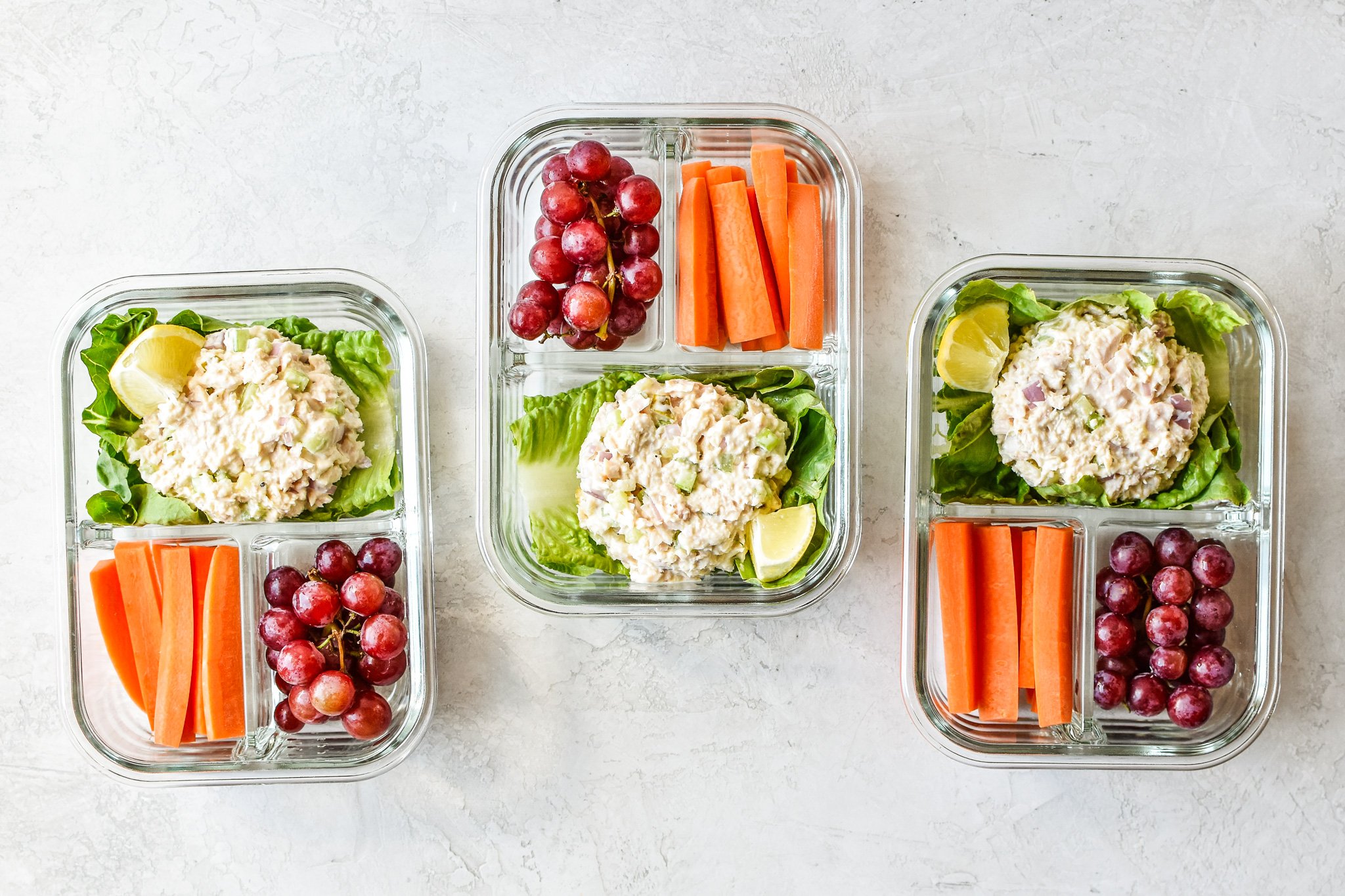Three tuna salad lettuce wraps meal prep lunches on the counter viewed from above.