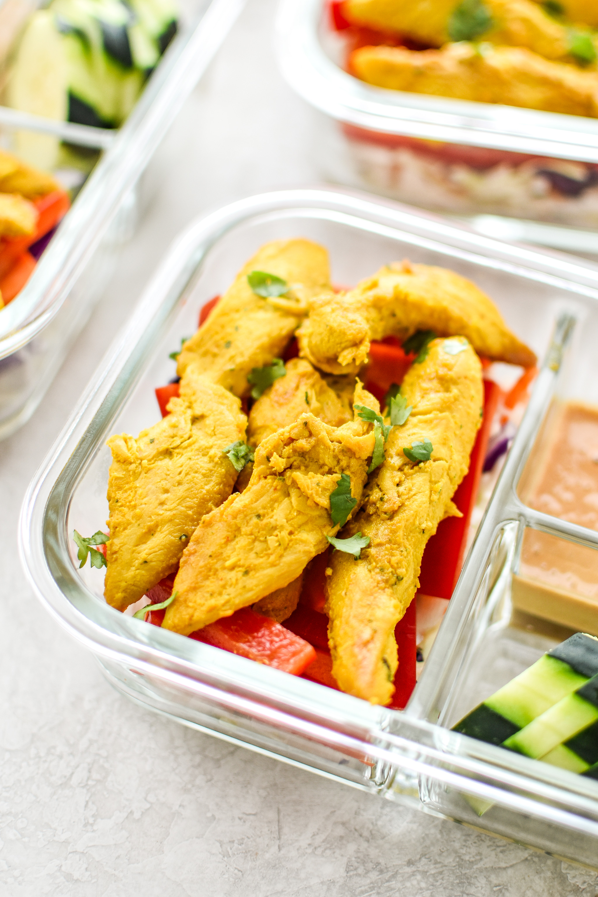 Meal Prep Satay Inspired Thai Chicken Salad Bowls portioned into meal prep containers, close up on the chicken.