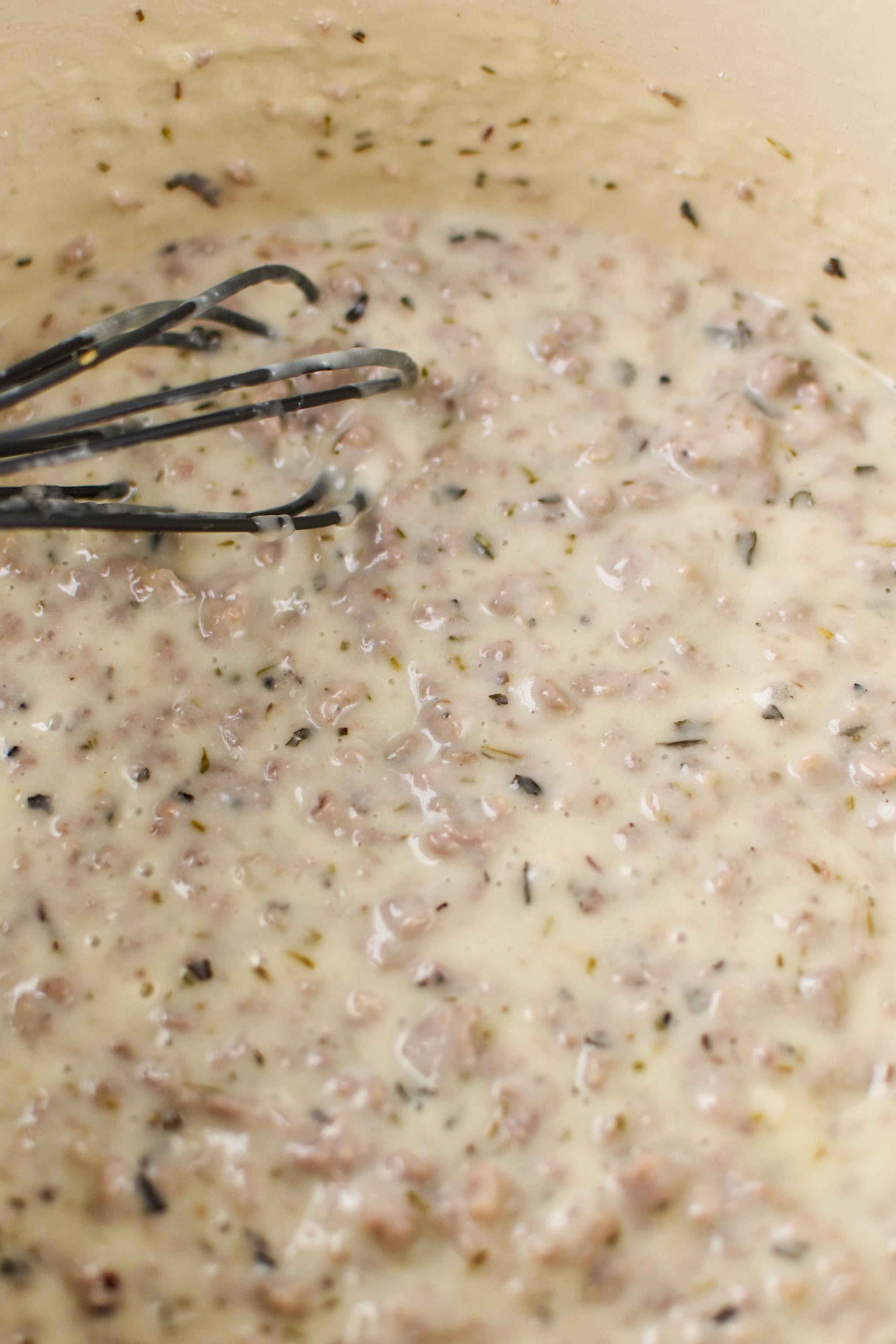 Sausage breakfast gravy cooked in a Dutch oven.