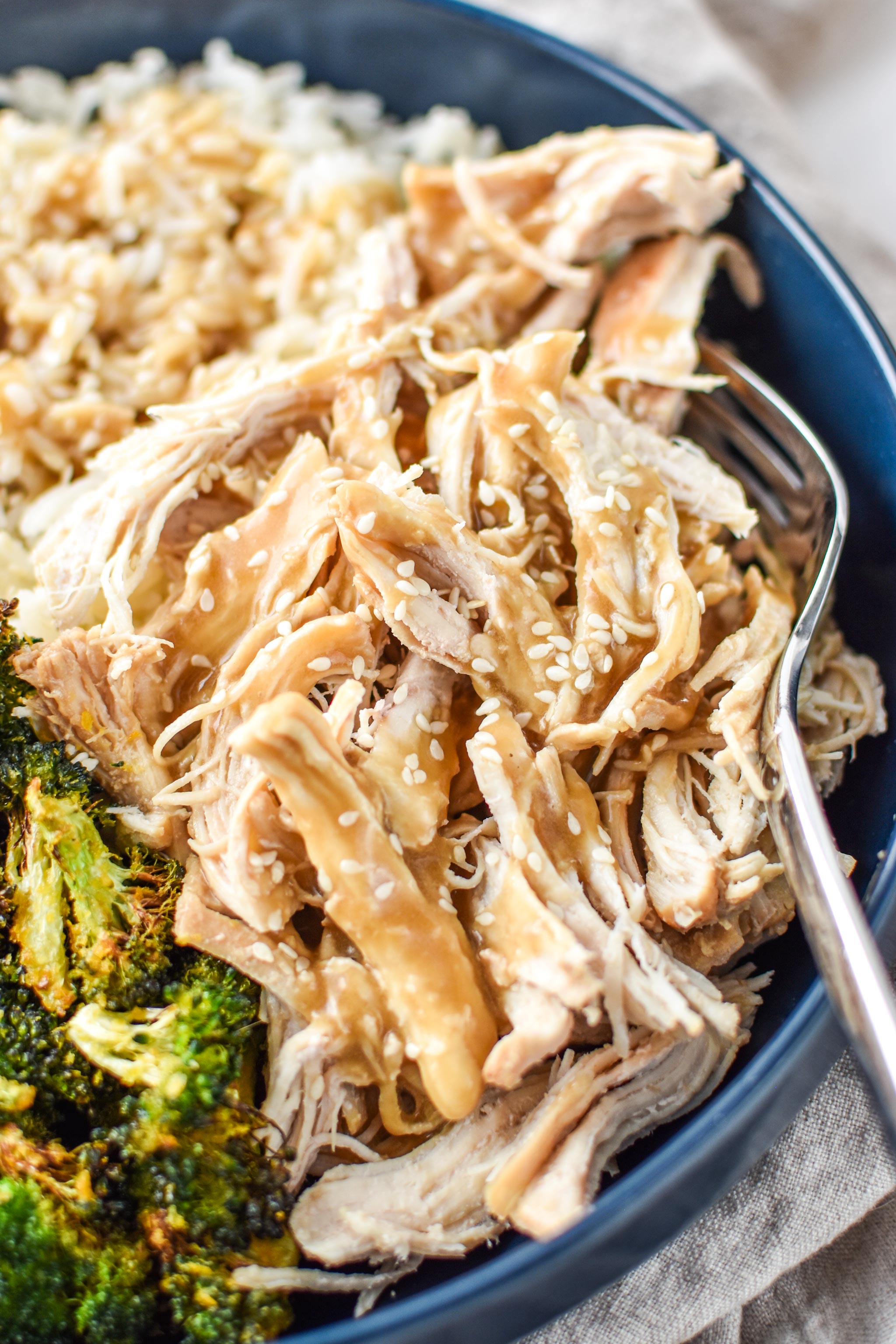 Sesame shredded chicken served with sauce, rice and broccoli