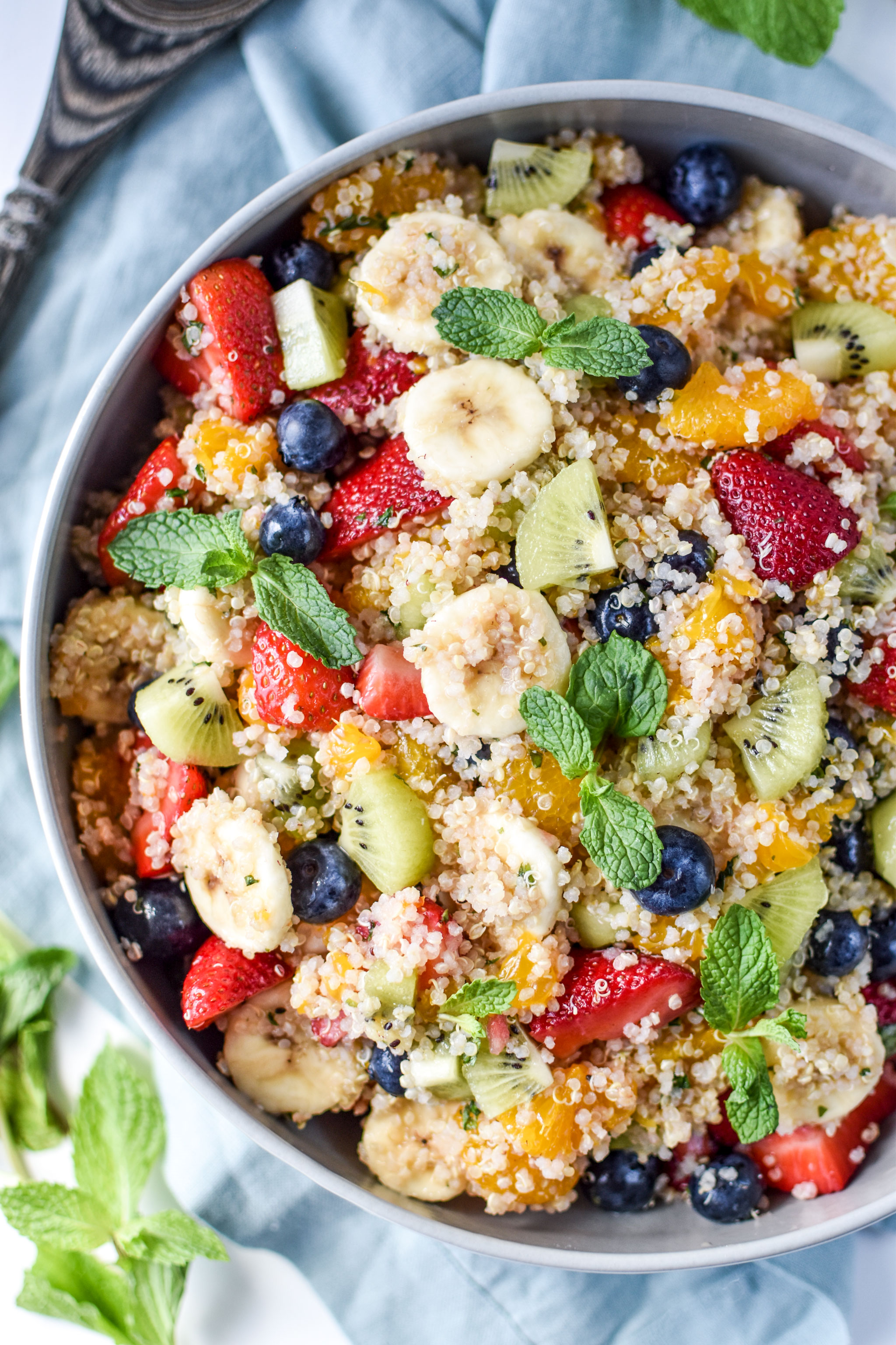 Mint Quinoa Fruit Salad pictured in a serving bowl with mint garnish