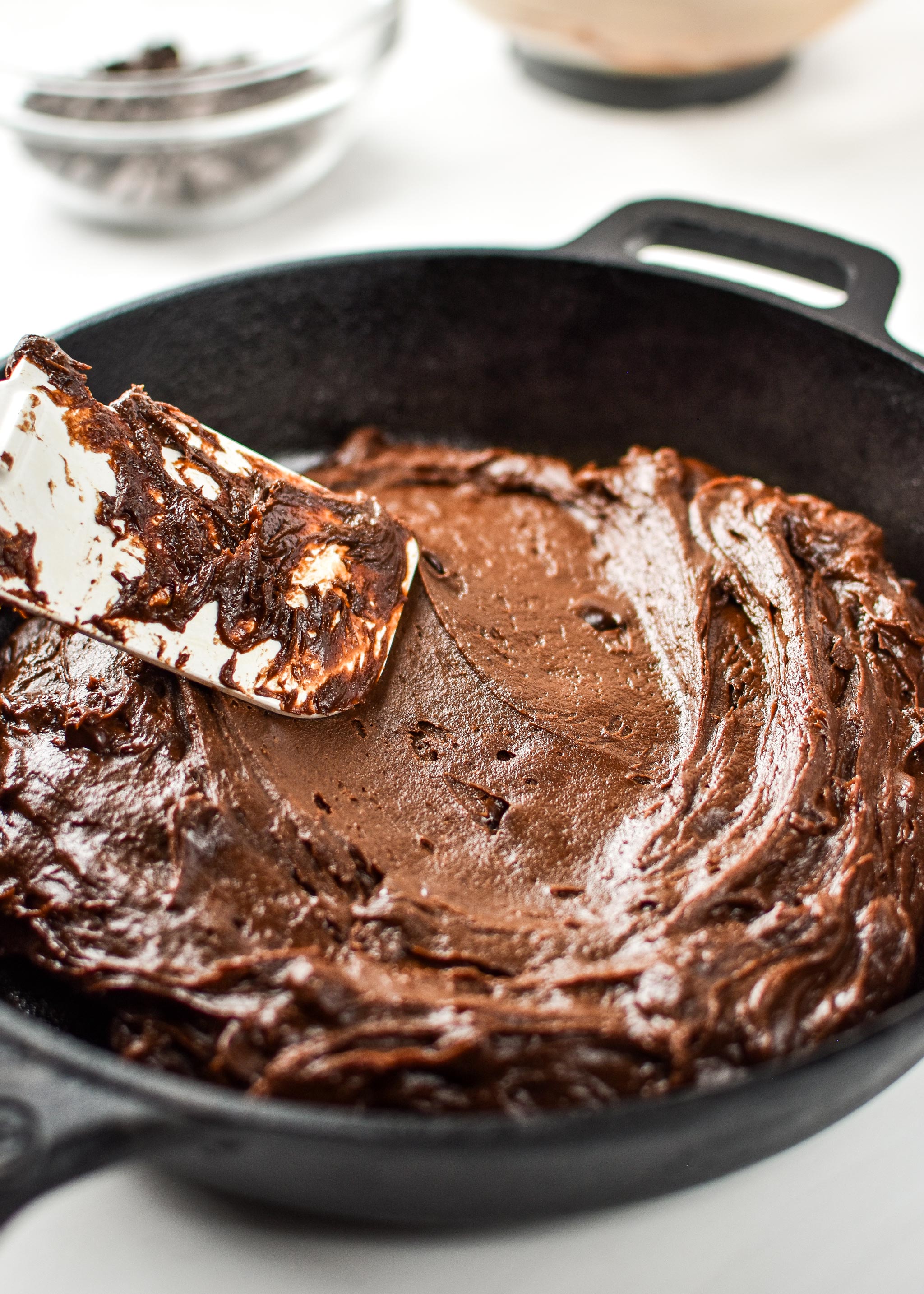Adding the batter to the cast iron skillet for the sweet potato brownie skillet