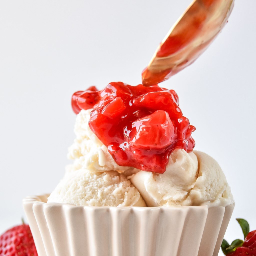 strawberry sauce on top of ice cream.