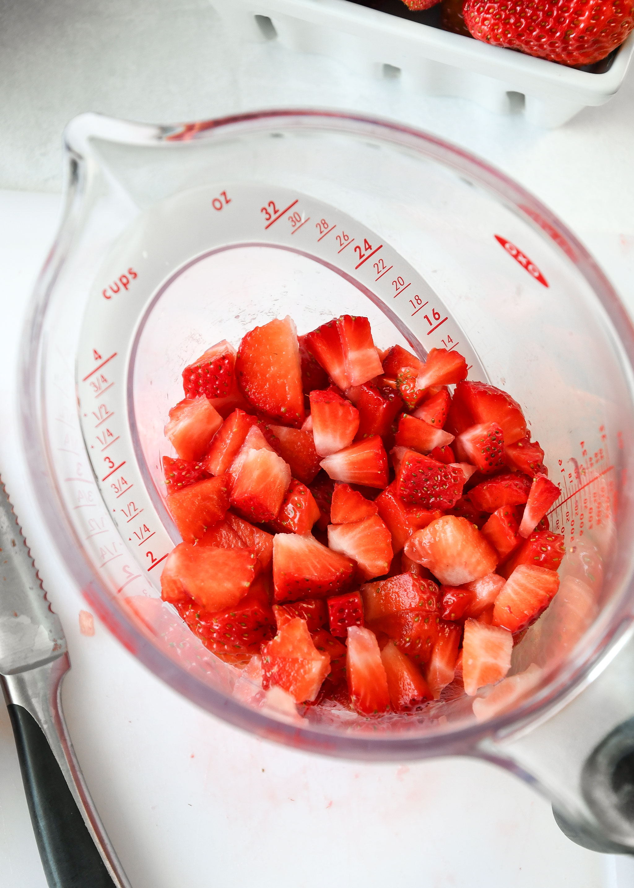 chopped strawberries in a measuring cup for easy strawberry sauce