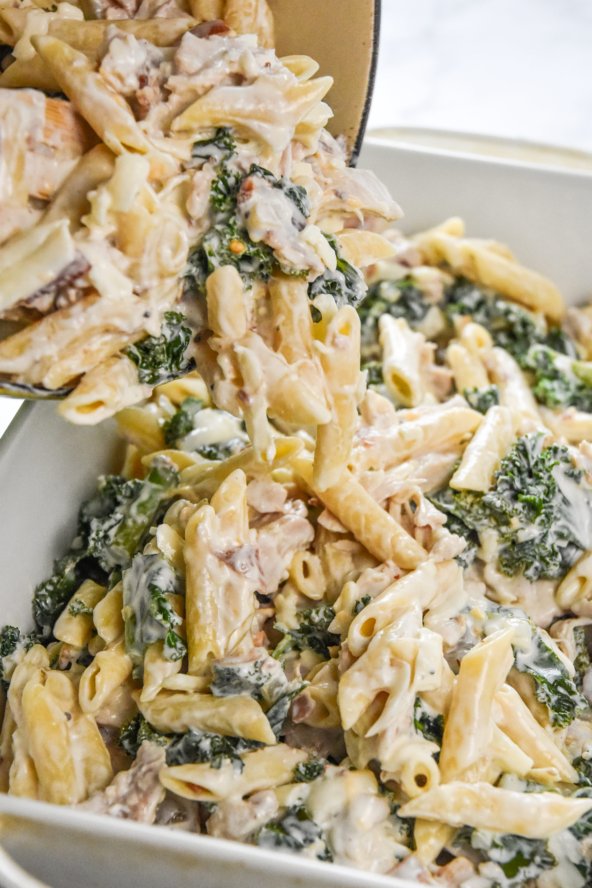 pouring the casserole mixture into the pan to make the cheesy chicken bacon ranch kale casserole