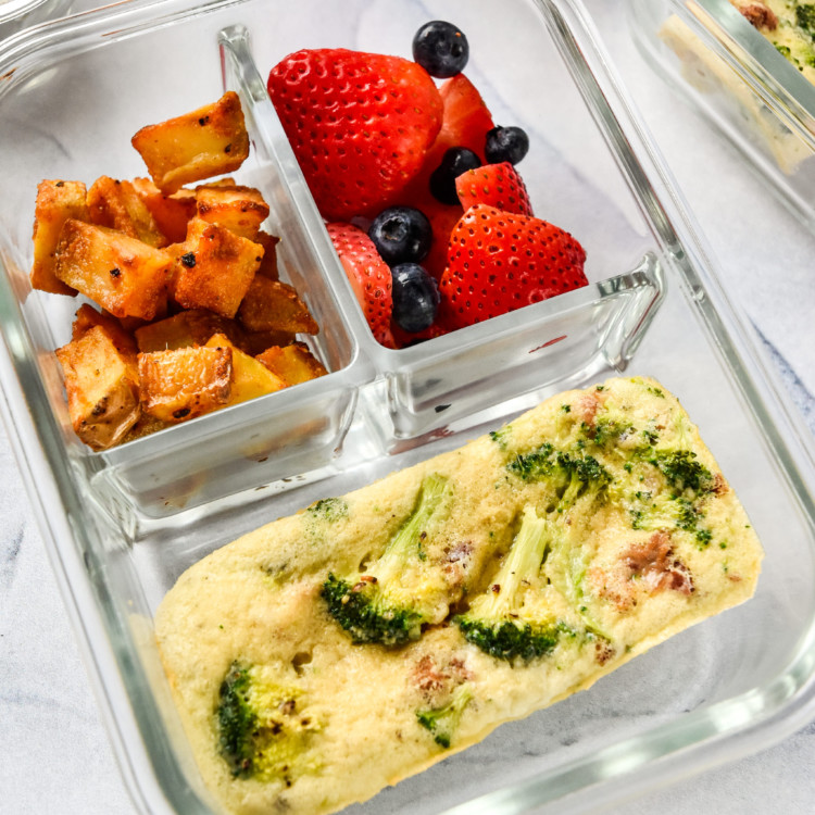 Broccoli bacon mini frittata in a meal prep container with potatoes and berries