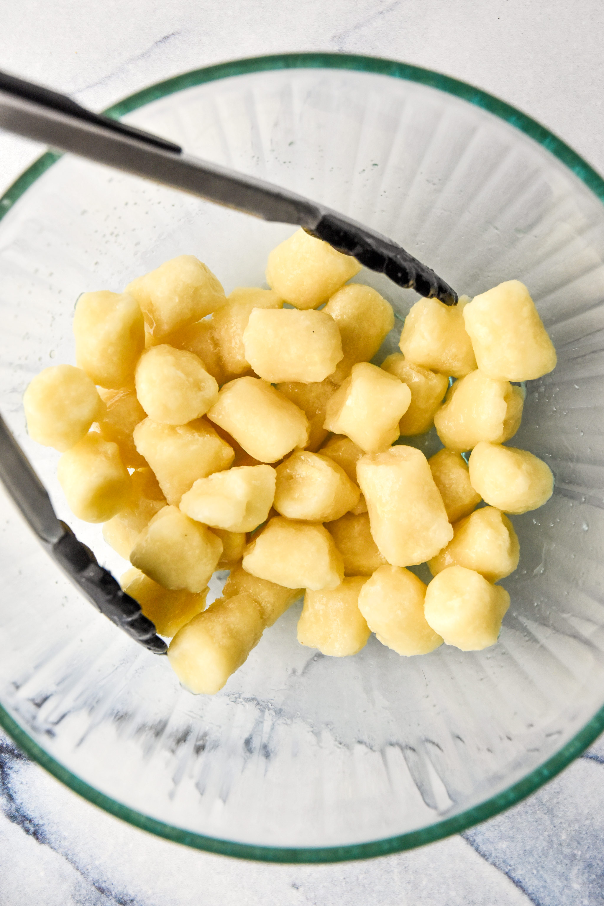 mixing up cauliflower gnocchi with oil and salt