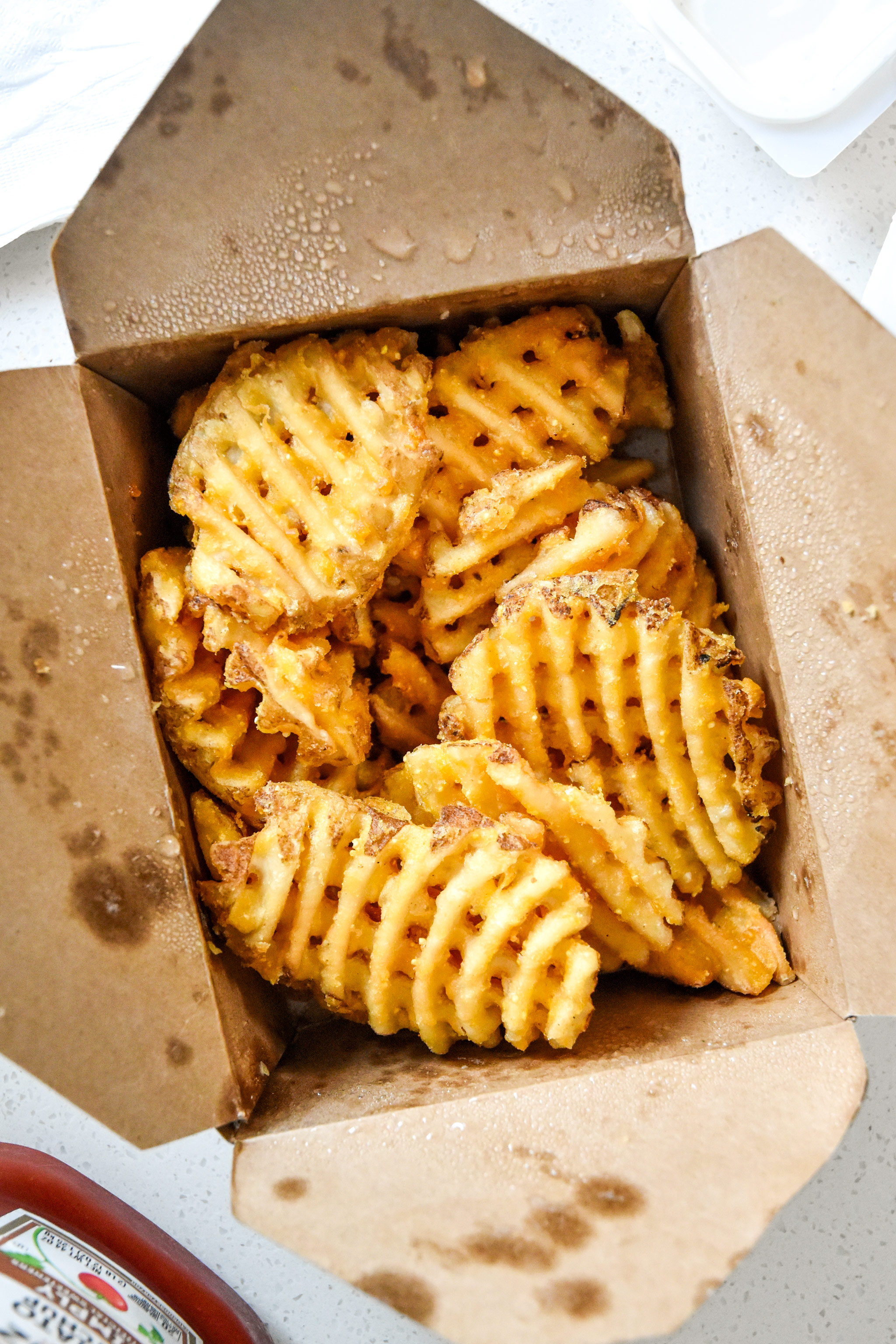 leftover waffle fries in a take out box