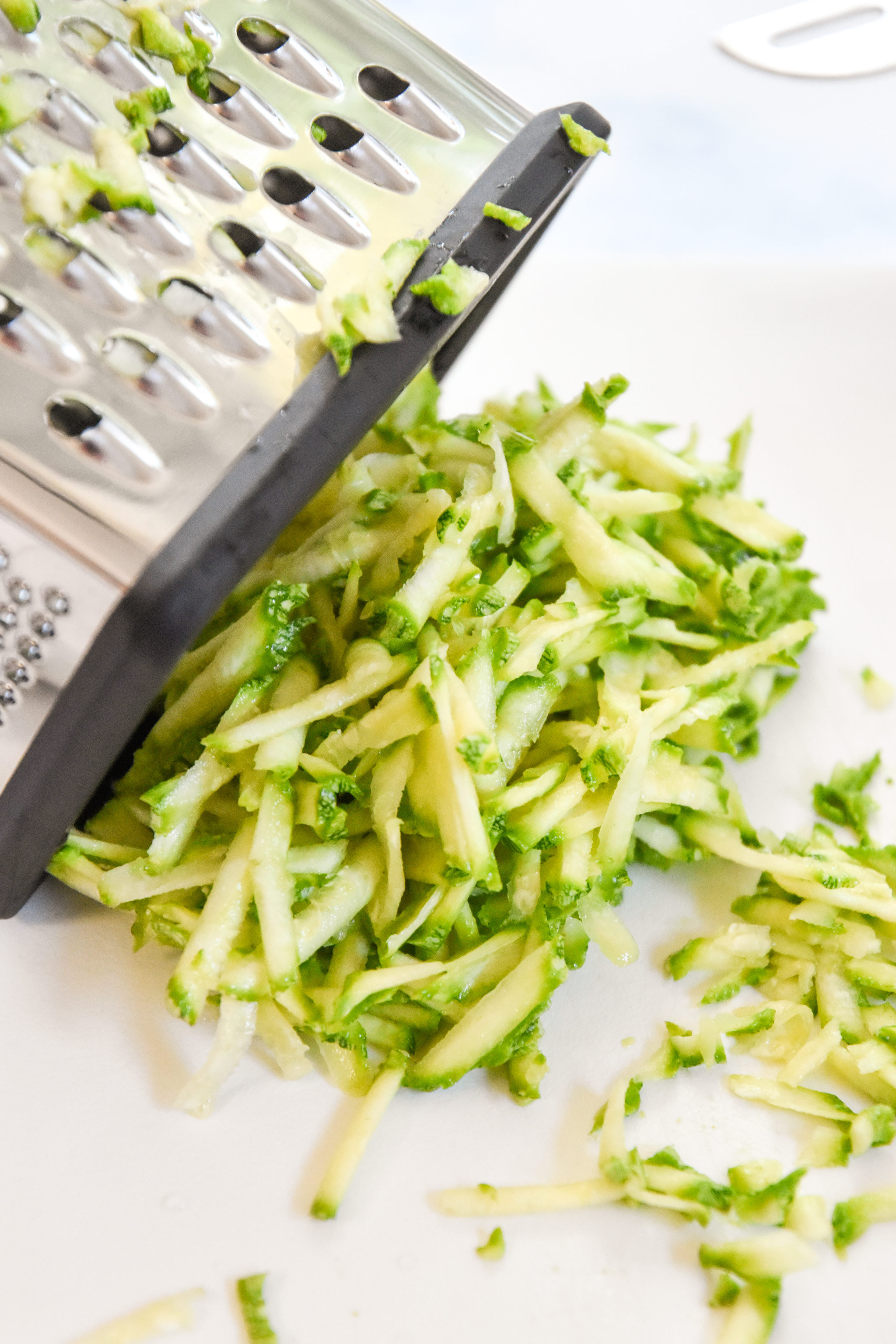 shredded zucchini with a box grater prepared to make muffins.