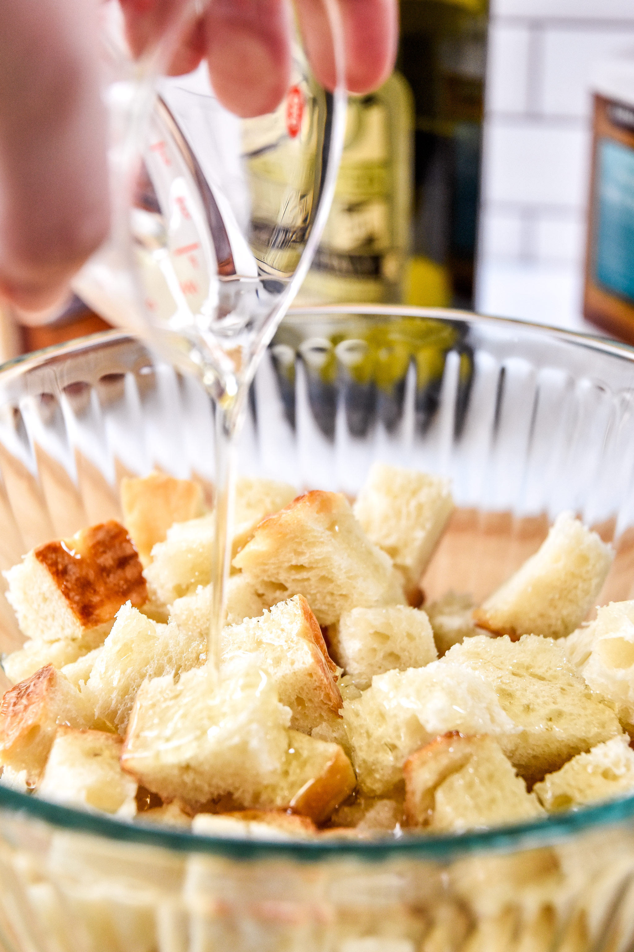 pouring oil on bread cubes to make croutons