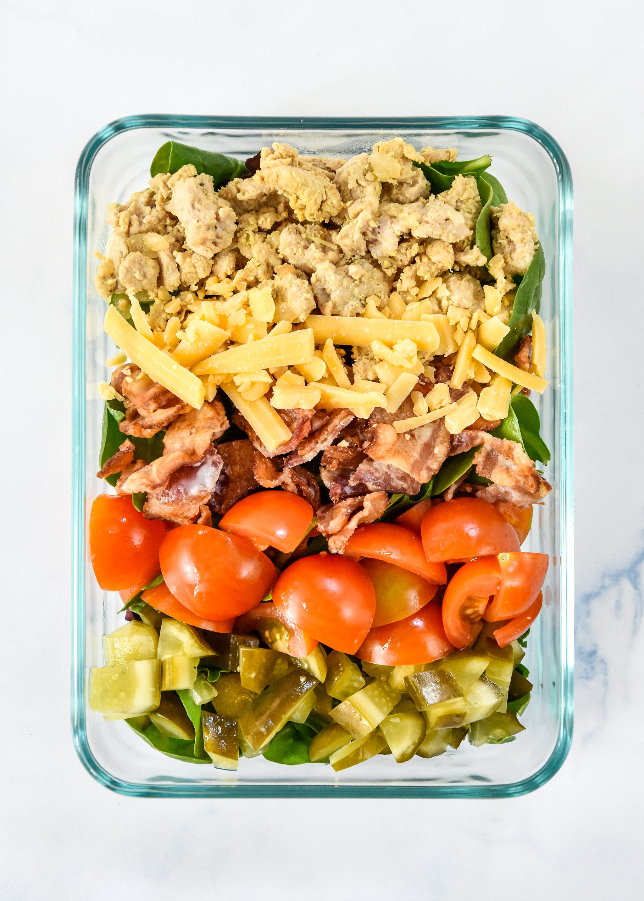 loaded ground turkey burger salad in a glass meal prep bowl.