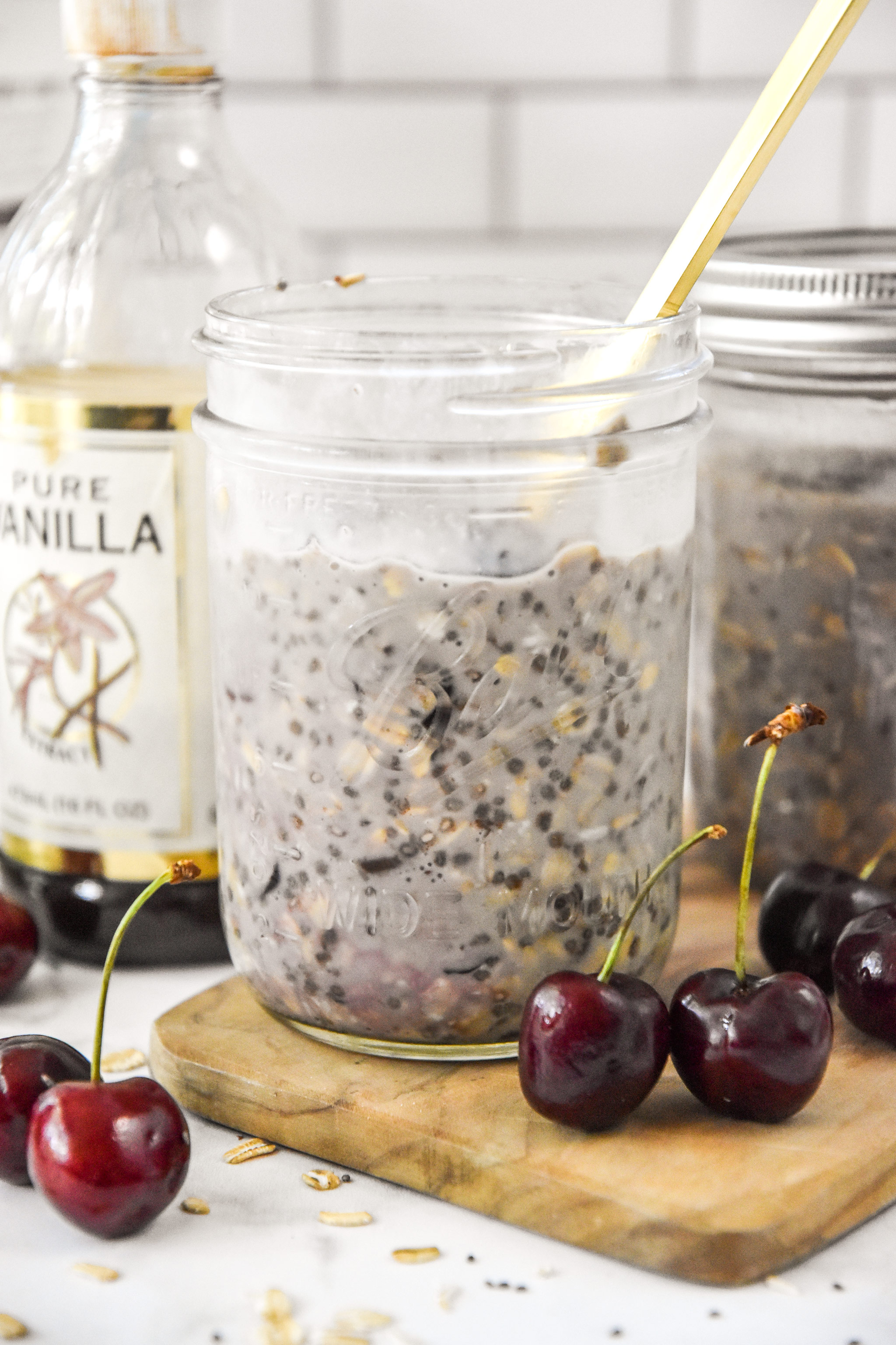 cherry vanilla overnight oats in a mason jar with cherries around.