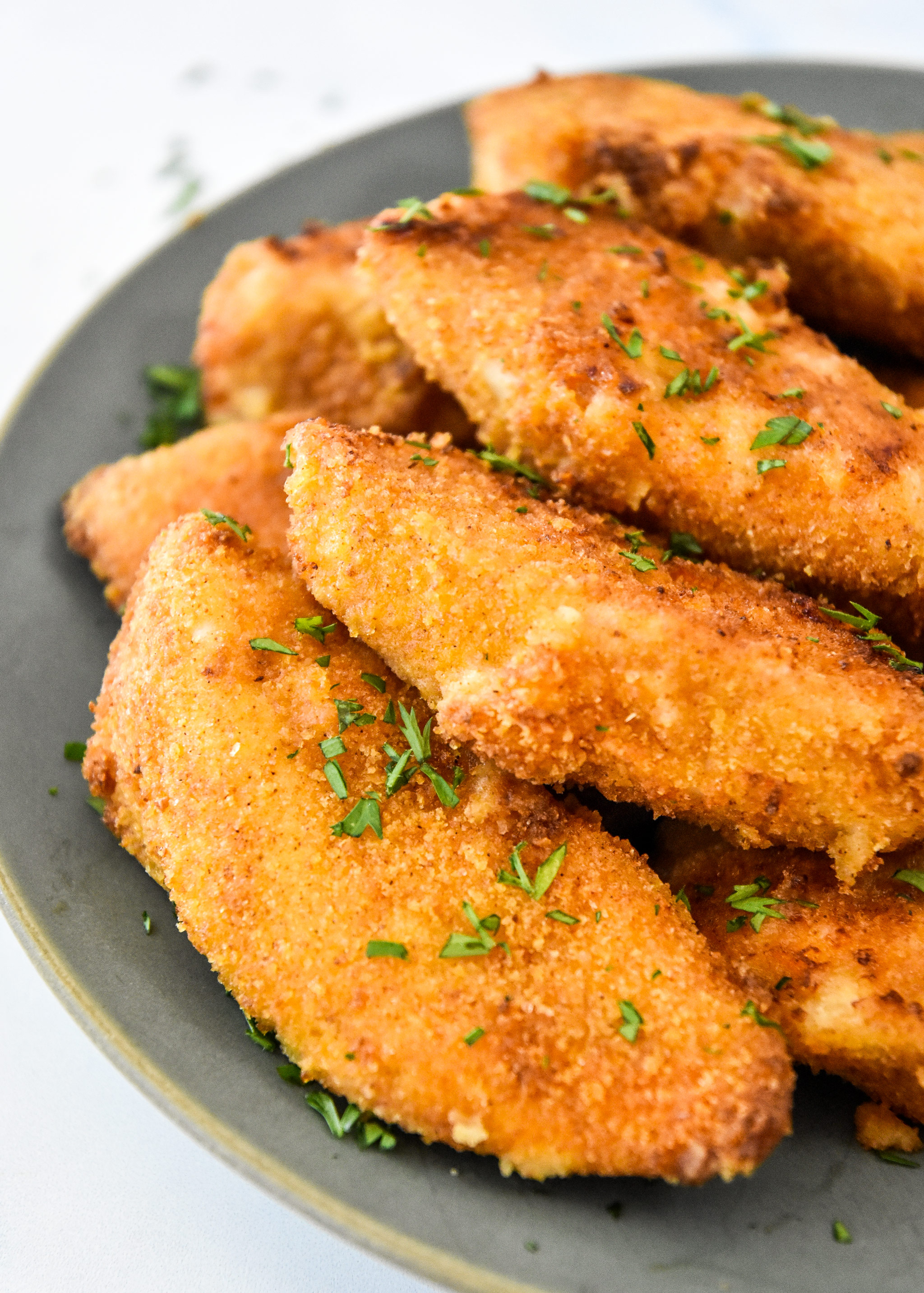 delicious air fryer breaded chicken tenders on a plate ready to eat.