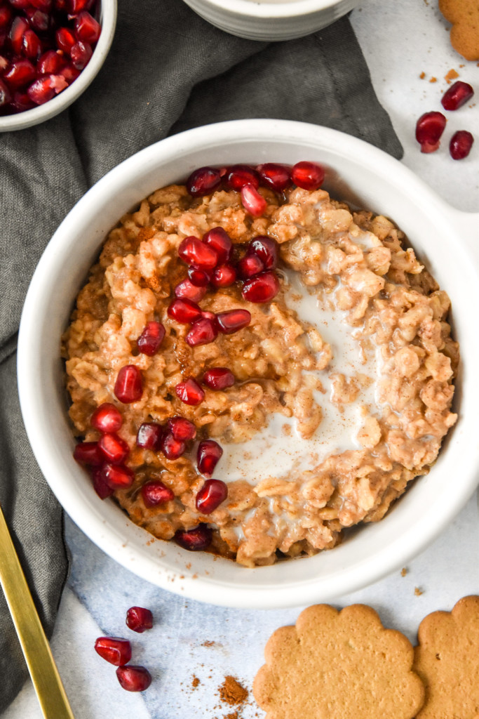 instant pot gingerbread oatmeal with brown sugar and pomegranate seeds on top.
