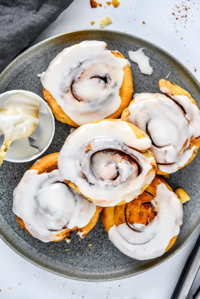 air fryer canned cinnamon rolls with icing on a plate.