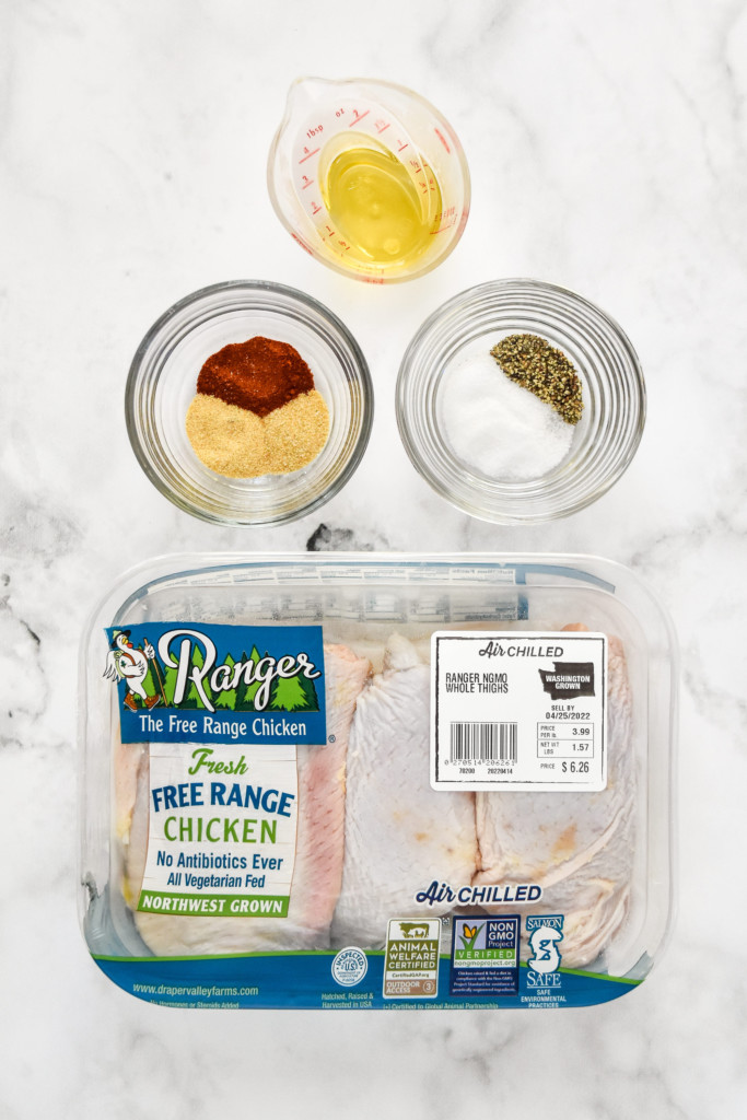 ingredients to make the air fryer bone-in crispy chicken thighs including chicken and spices.