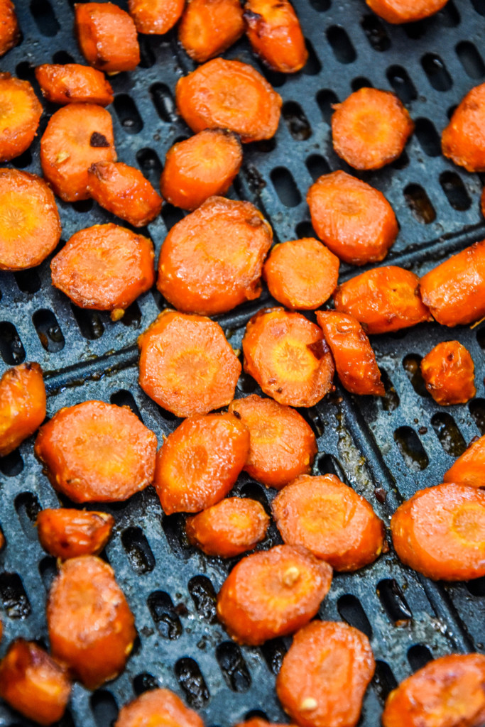 close up of cooked air fryer hot honey glazed carrots in the air fryer basket.