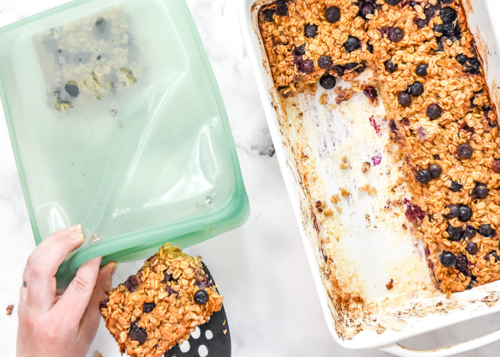 portioning the easy blueberry lemon baked oatmeal into airtight containers for the fridge.