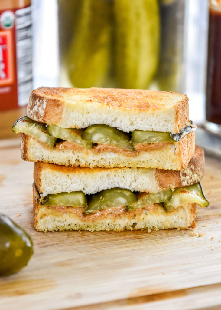 air fryer peanut butter sandwiches pickle version cut in half stacked on a cutting board.