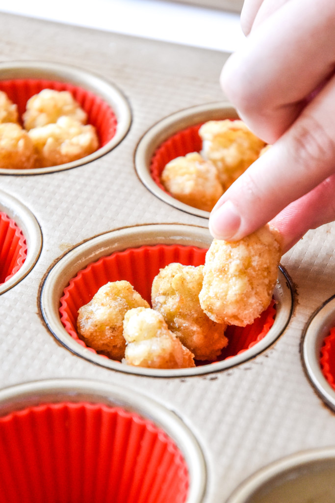 adding tater tots to the muffin pan.