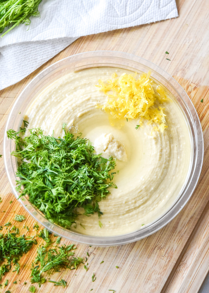 making lemon dill hummus for the with fresh lemon zest and chopped dill.
