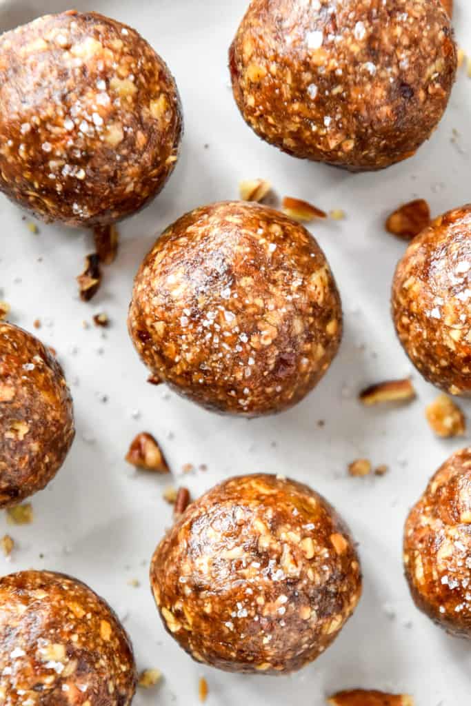 close up of a no-bake pecan pie date ball with some salt on top.