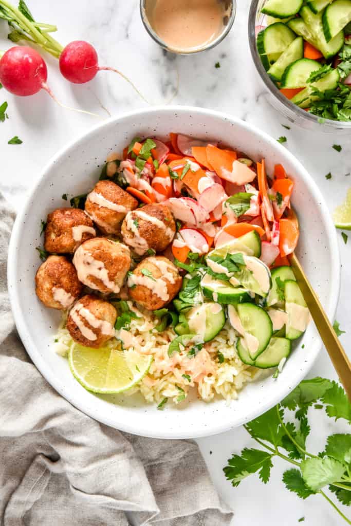 banh mi inspired meal prep bowls with spicy mayo sauce drizzled on top.