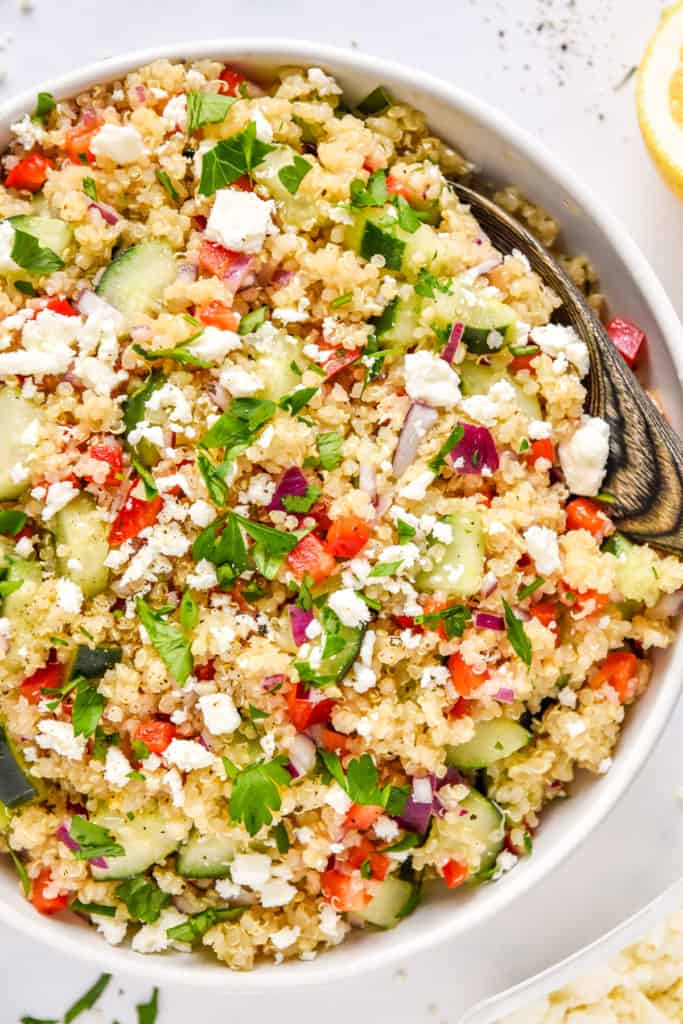 make-ahead quinoa party salad with feta and chopped parsley on top.