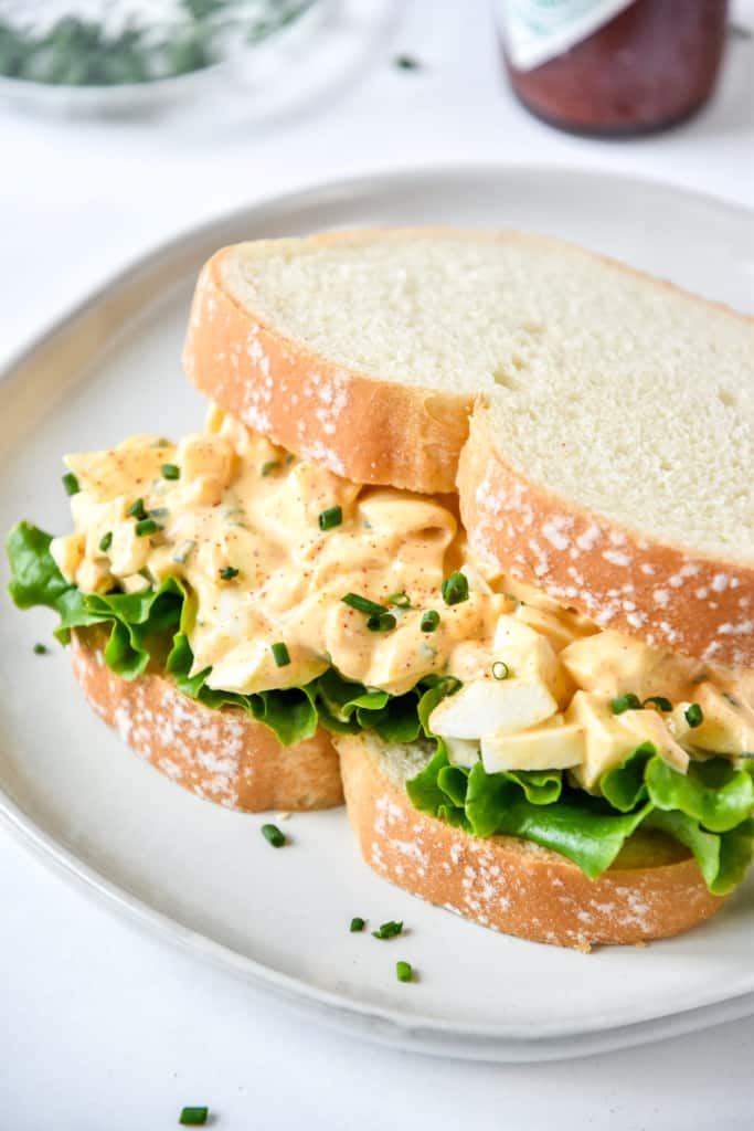 Easy Deviled Egg Salad on white bread with lettuce.