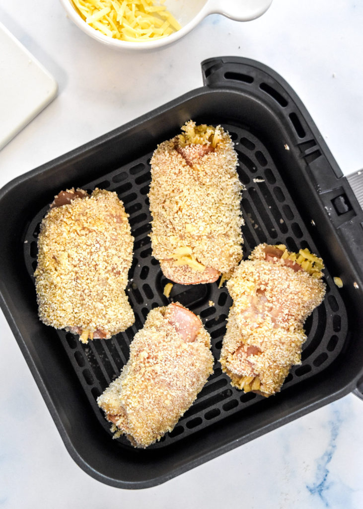 raw chicken cordon bleu in the air fryer basket before cooking.