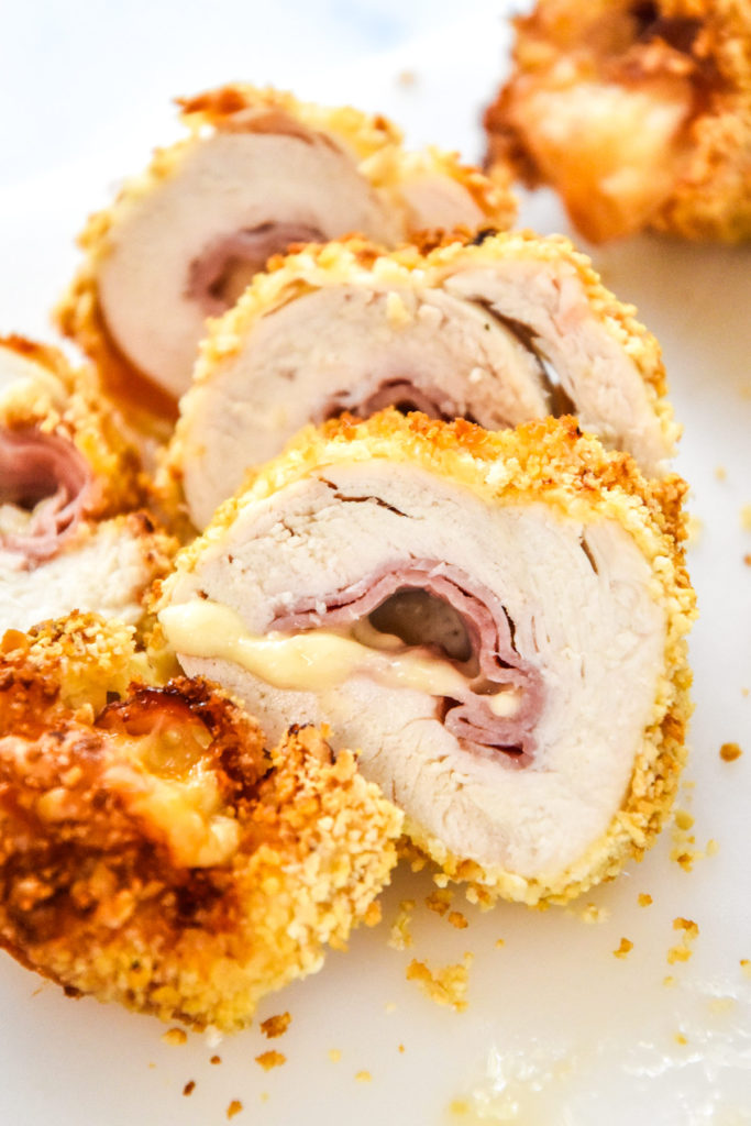 air fryer chicken cordon bleu sliced into pieces with melting cheese coming out.