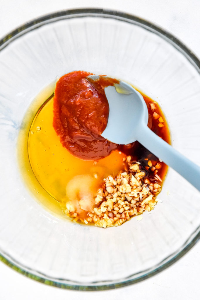 honey, sriracha, garlic and soy sauce in a glass bowl before stirring.