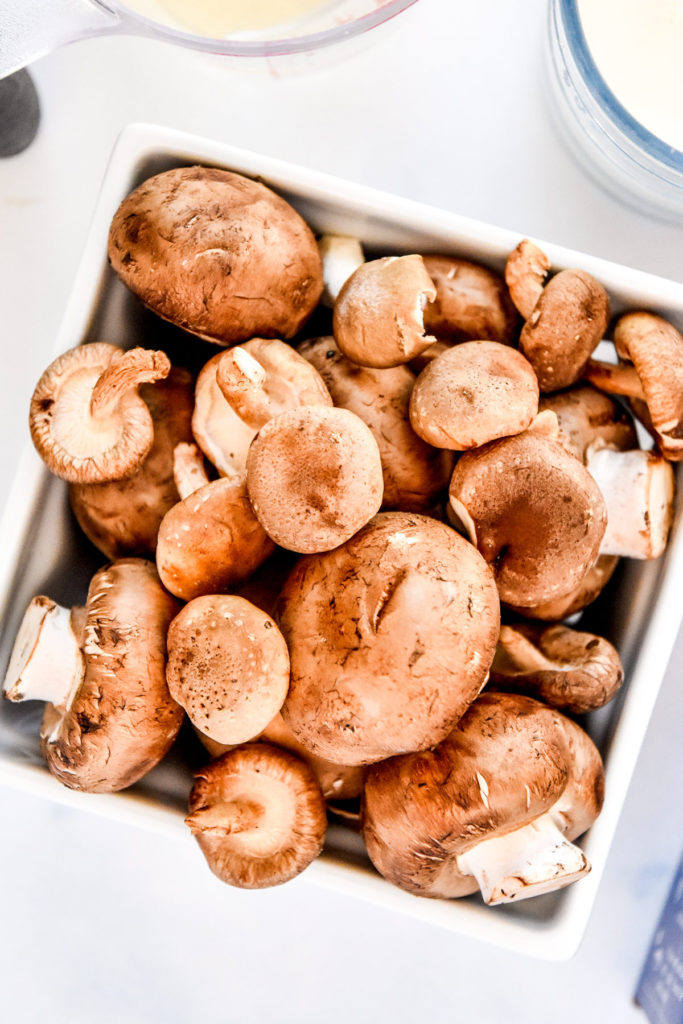 cremini and oyster mushrooms in a white pin dish.