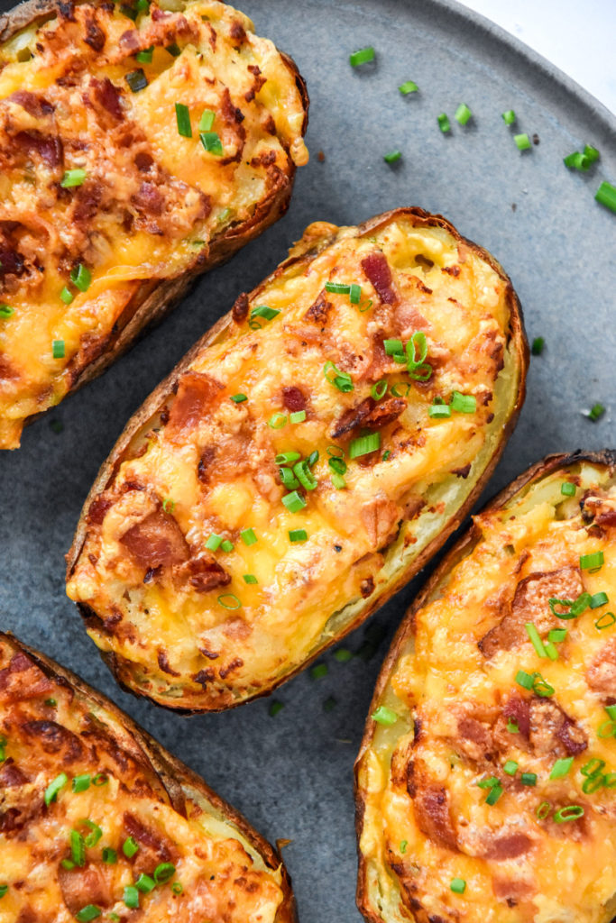 Air Fryer Twice Baked Potatoes with cheese, bacon bits and chives on top.