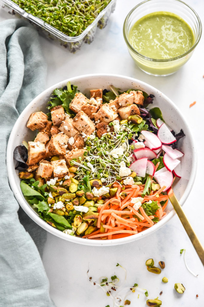 simple spring mix lunch salad with radish, microgreens, carrots, and diced chicken.