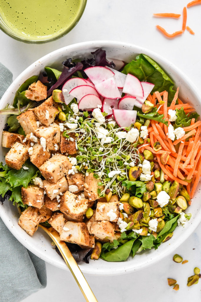 simple spring mix lunch salad with radish, microgreens, carrots, and diced chicken.