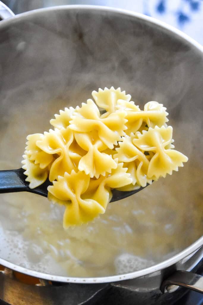 cooked bowtie pasta on a spoon.