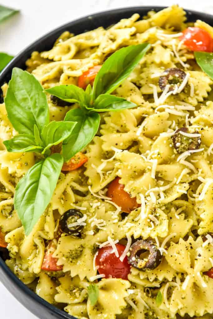 easy pesto pasta salad with fresh basil on top.