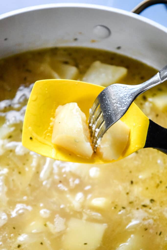 piercing a cooked potato with a fork to check for doneness.