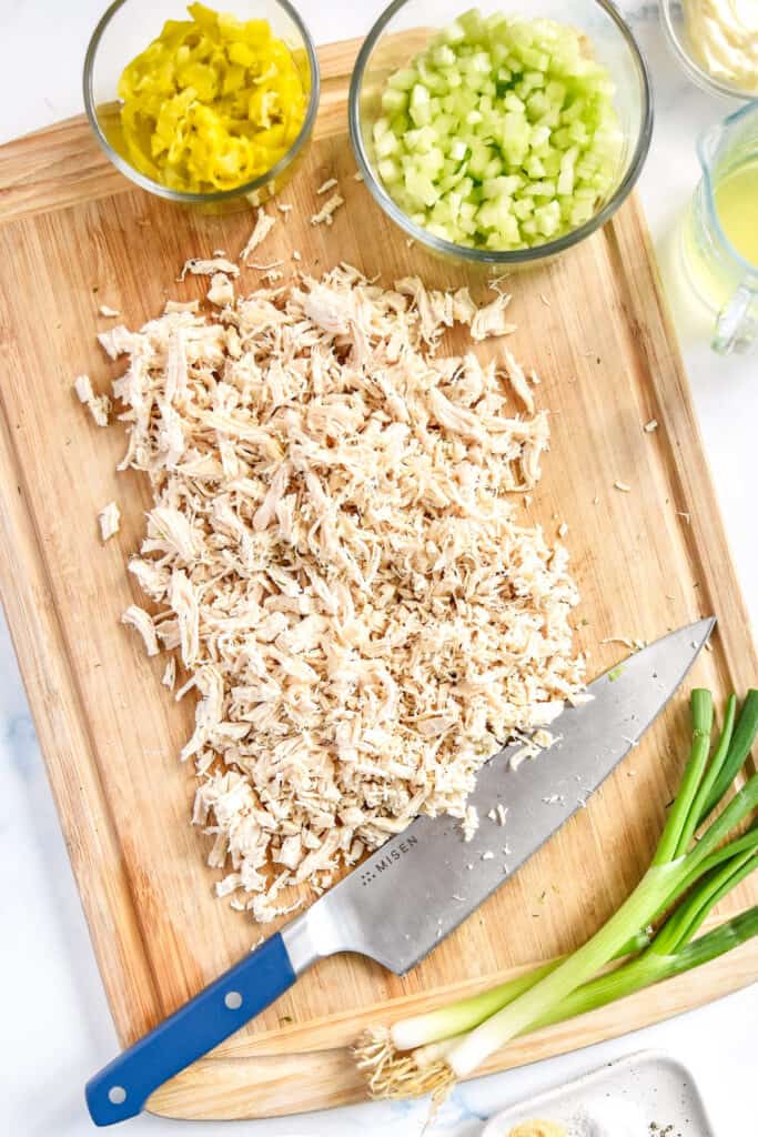 cutting shredded chicken on a cutting board.