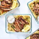 moroccan inspired spiced chicken couscous bowls in glass meal prep containers.
