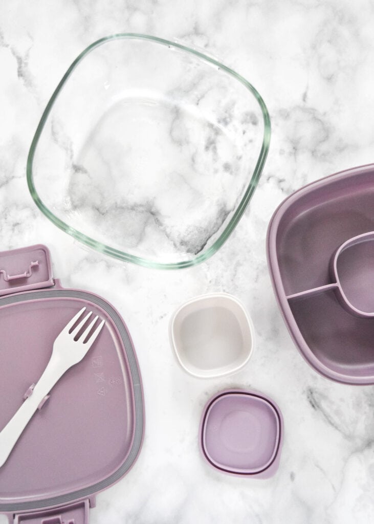 meal prep container with built in sauce cup and fork with pieces spread out.