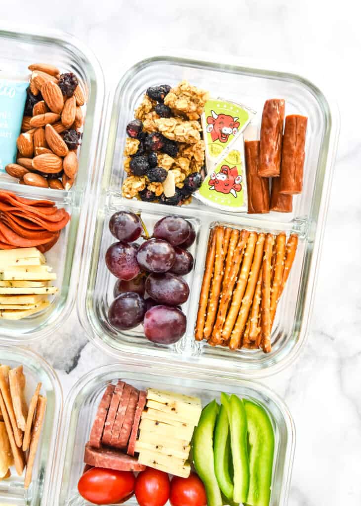 cheese, pretzels, grapes and granola in a glass meal prep container to make a DIY Adult Lunchable.